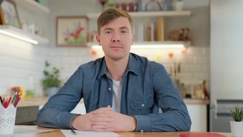 Jeune blogueur décontracté regardant la caméra parlant et enregistrant un vlog de style de vie à la maison,