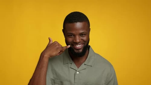 Smiling Man Makes Call Me Hand Gesture