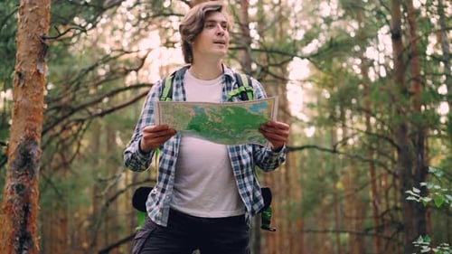 Handsome Young Man Traveler Is Walking in Forest Then Standing and Looking at Map