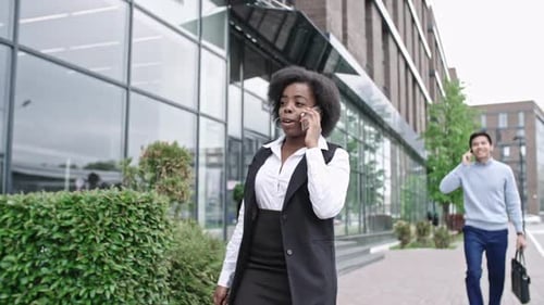 Business Woman Talking on Phone Walking by Office