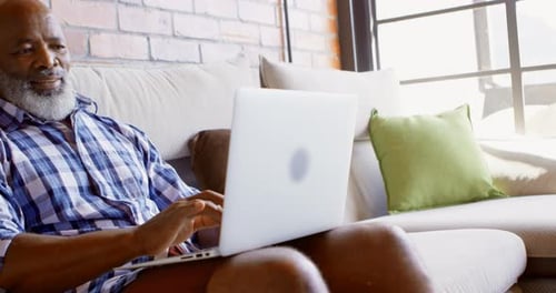 Senior Man Works on Laptop at Home
