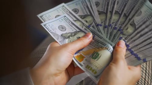 Close Up Counting Stacks of US Dollar Currency