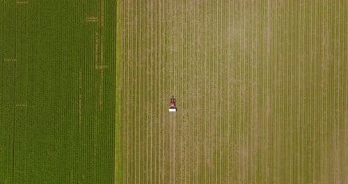 Fertilizer spreader in a large field, Aerial follow footage.