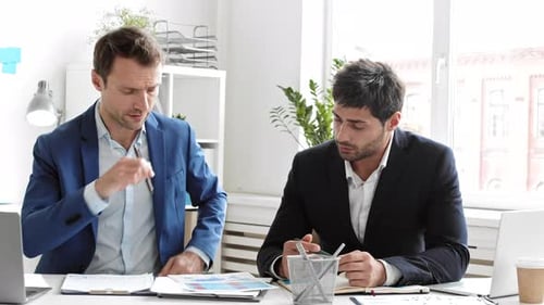 Coworkers Analyzing Documents in Office