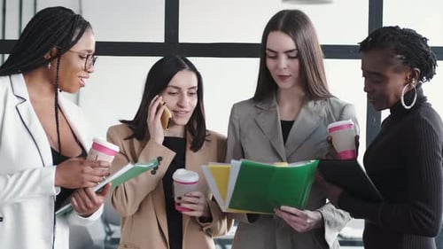 Business Women Team Meeting with Files and Coffee