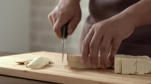 Chopping Tofu on a Wooden Cutting Board