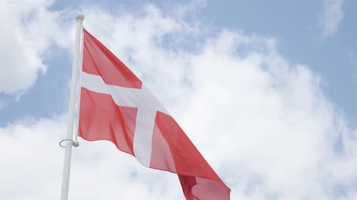 Denmark national flag in front of cloudy sky waving 4K 2160p 30fps UHD footage - Red and white Dani