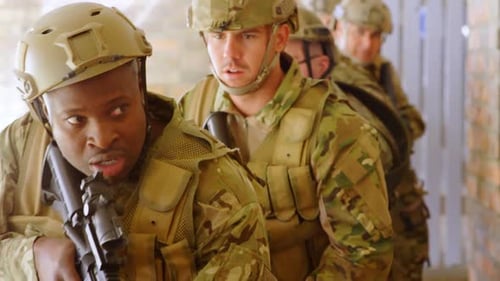 Front view of mixed-race military soldiers walking with rifles during military training 4k