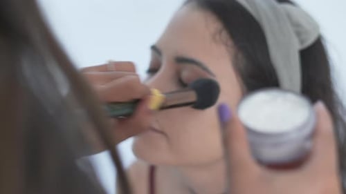Young Woman Having Makeup Applied With Brush