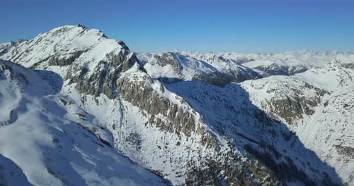 Aerial drone view of snow covered mountains in the winter.