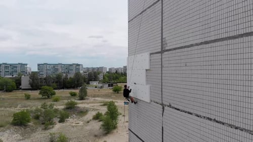 Industrial Alpinism. Aerial View. Work on Outer Insulate Building with Styrofoam