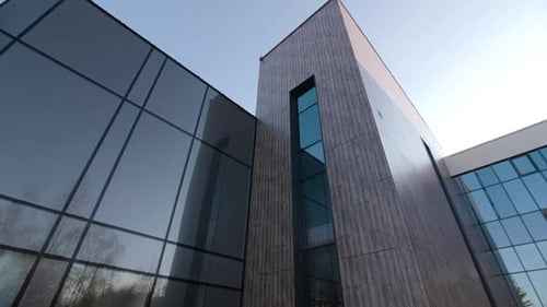 Elegantes Bürogebäude mit dunkler Glasfassade auf der Straße
