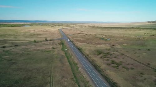 Aerial View of an Intercity Asphalt Road in Rural Area Road Between Fields with Rare Trees