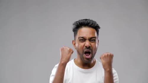 Glücklicher indischer Mann feiert Sieg 19