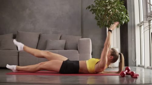Woman Doing Leg Lifts and Stretching at Home