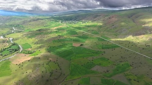 Petites maisons de village entourées de prairies verdoyantes et de collines basses dans une géographie douce standard