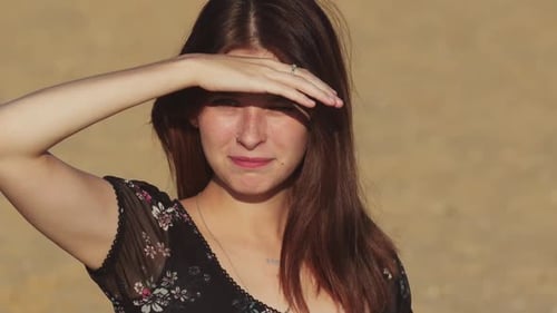 Young Woman in Black Dress on the Beach