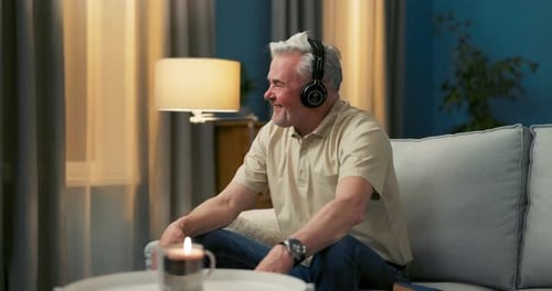 Smiling Man Listening to Music at Home