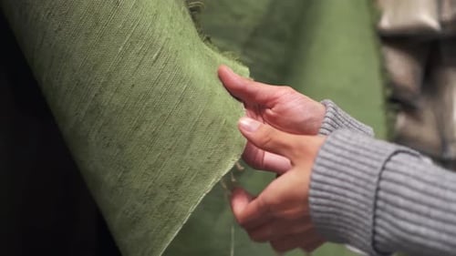 Female Hands Touch The Burlap Fabric. Roll Of Fabric Rough Texture Hands Hold The Fabric