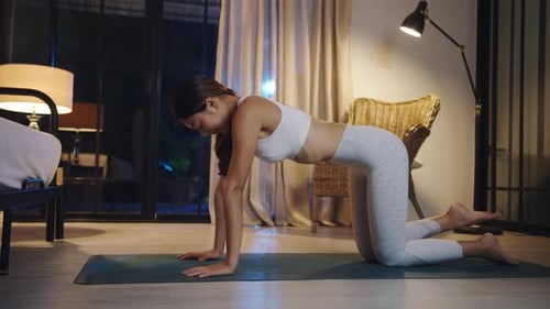 Woman Doing Yoga Exercise at Night Indoors