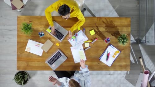 Overhead View of Two Adults Collaborating on Laptops