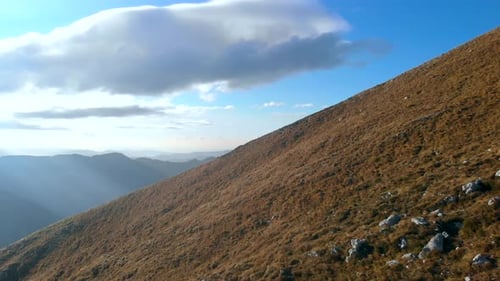 Flying over grassy slope in Julian alps. Aerial shot of mountain slope. Autumn in mountains, drone s