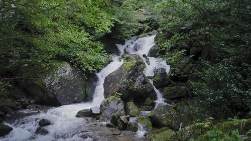 Wasserfall zwischen Bäumen und Steinen