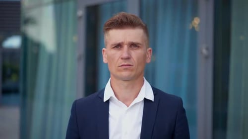 Stressed Young Businessman Rubbing Temples in City