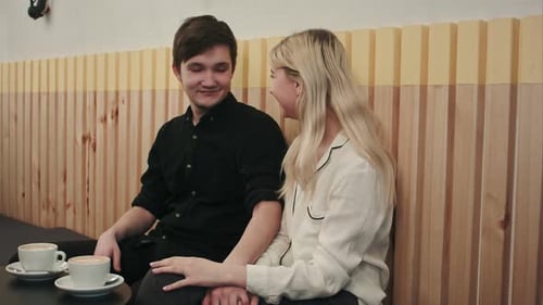 Cute Happy Couple Enjoying a Cup of Coffee While on a Date at a Cafe
