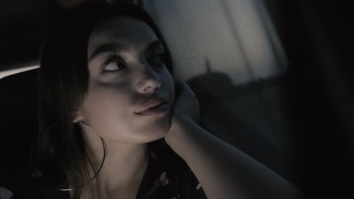 Woman Looking Out Car Window at Night