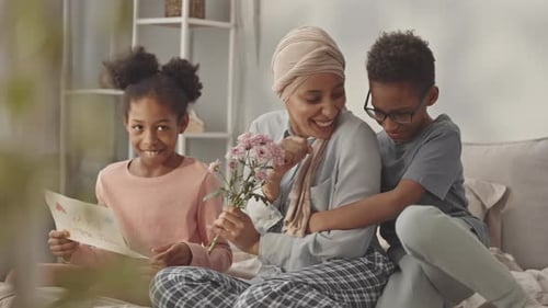 Affectionate Family Celebrating Mother's Day with Card and Flowers