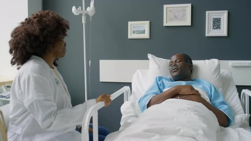 Patient Speaking with Female Doctor in Hospital Ward