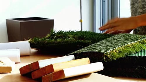 Business executive examining artificial turf
