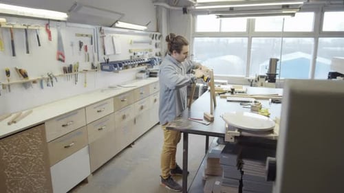 Young Tradesman Making Piece of Furniture in Workshop