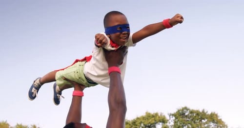 Father and Son Playing Superhero Together Outdoors
