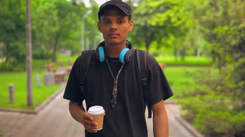 Man Walking in Park with Coffee Cup