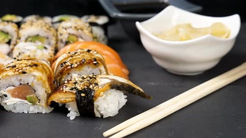 Mix Variety of Sushi Rolls on Black Stone Background
