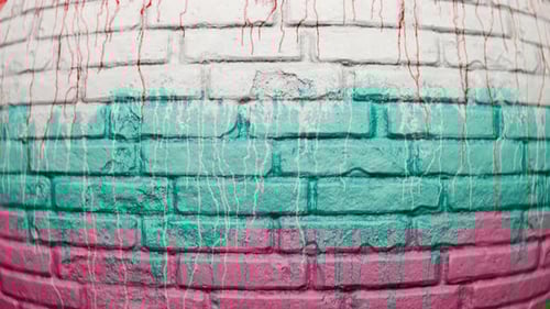 Colorful Paint Dripping on a Textured Brick Wall