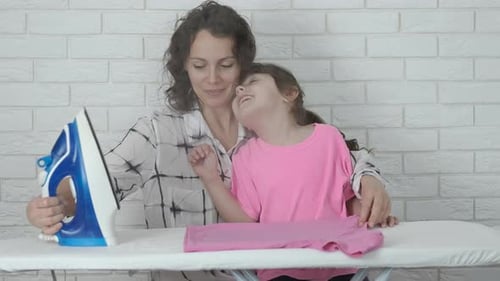 Woman and Girl Ironing Together at Home
