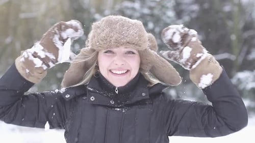Happy Young Woman Playing in Snow in Winter Holidays