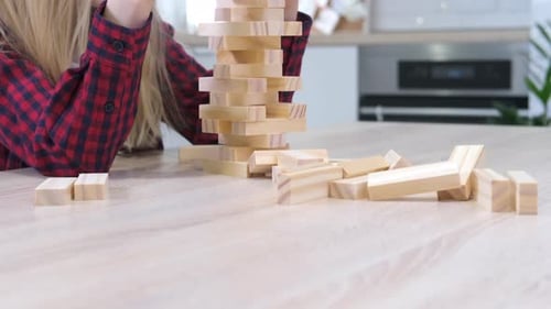 Kinder spielen zu Hause einen Turm zum Entfernen von Holzklötzen