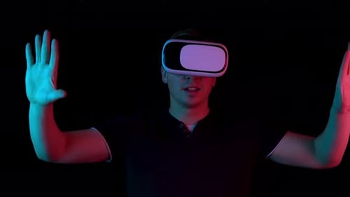 Young Adult Using VR Headset in Dark Room