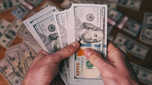 Hands Displaying Stack of One Hundred Dollar Bills