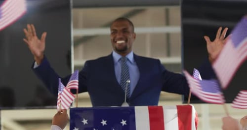 Man Giving Speech at Podium with American Flags