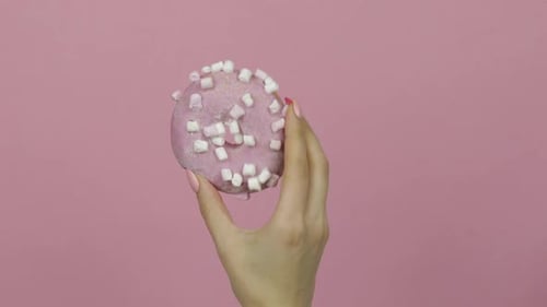 Hand Holding Pink Donut with Marshmallows