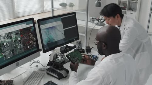 Engineers Examine Computer Chip in Bright Lab