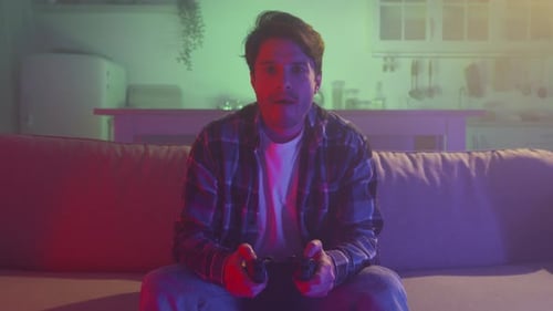 Man Plays Video Games at Night on Couch