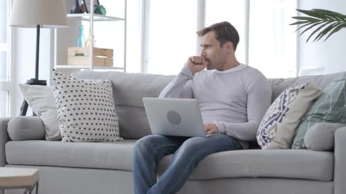 Man Using Laptop While Sitting On Couch