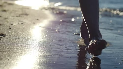 Woman Walking Barefoot on Beach at Sunset