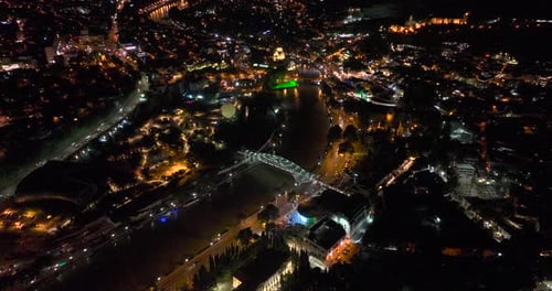 Night aerial view of Bridge of Peace and beautiful cityscape in the center of Tbilisi, Georgia 2022